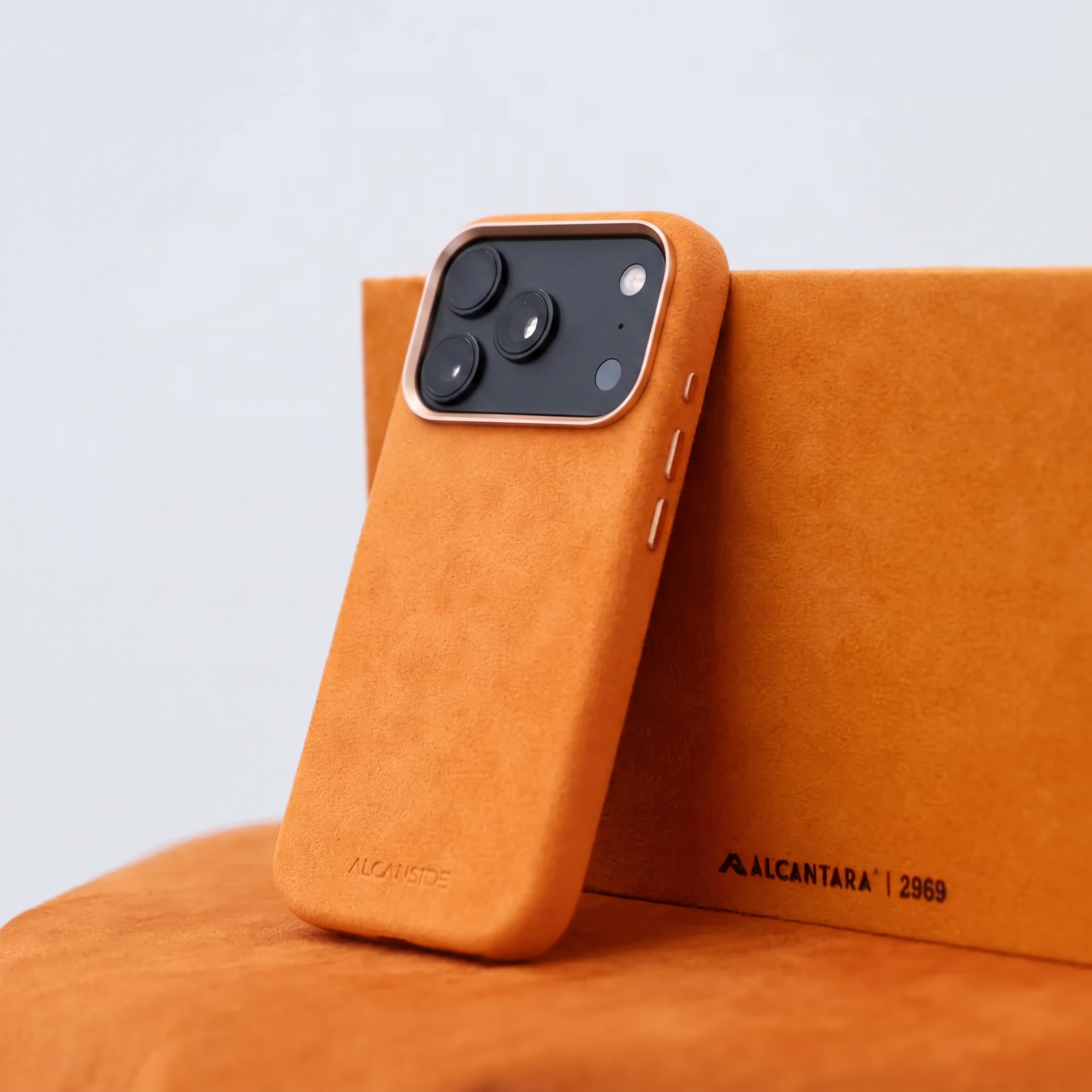 Orange Alcantara case for iPhone 18 Pro Max held in hands